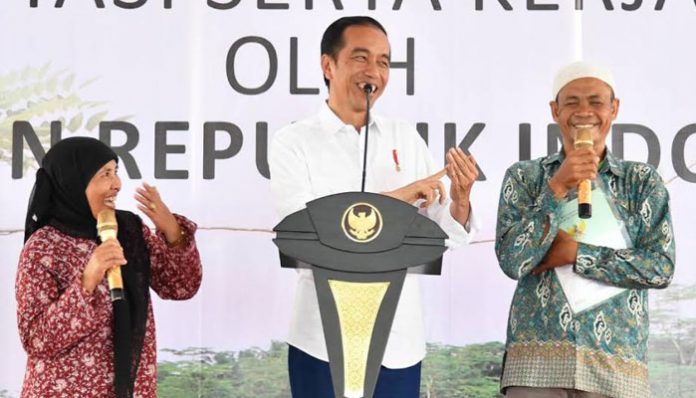 Presiden Jokowi Sedang Mebagikan Sertifikat Tanah kepada Warga.