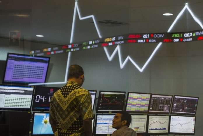 Dua karyawan mengamati pergerakan Indeks Harga Saham Gabungan (IHSG) di Bursa Efek Indonesia