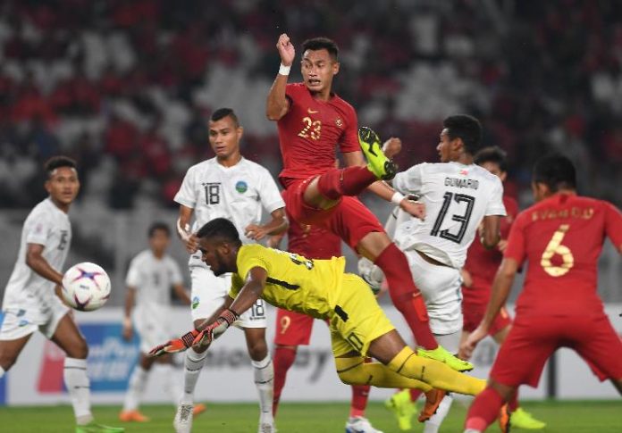 Pemain Timnas Indonesia Hansamu Yama (atas) berebut bola dengan sejumlah pesepak bola Timor Leste