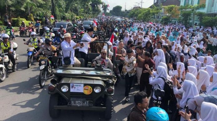 Khofifah dan Emil disambut barisan pelajar SMA/SMK di sepanjang perjalanan dari Masjid Nasional Al Akbar Surabaya menuju Monumen Pahlawan Surabaya, Kamis (14/2/2019).