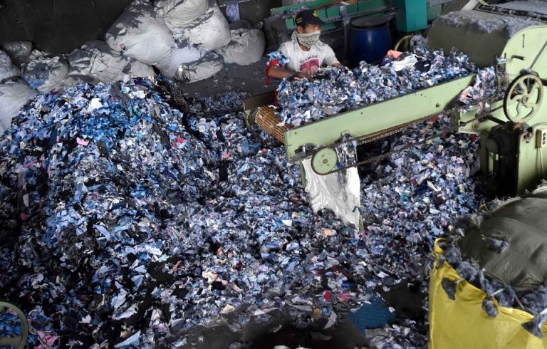 Pekerja mendaur ulang kain-kain perca limbah industri garmen.