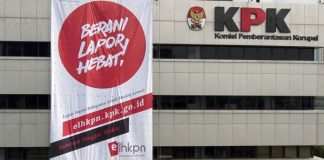 Empat pemanjat profesional membentangkan spanduk yang bertuliskan "Berani Lapor Hebat" di gedung KPK C1 Jalan HR Rasuna Said, Jakarta (26/3).