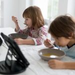 ilustrasi anak makan sambil menonton gadget