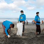 ilustrasi warga bersih-bersih sampah di pantai