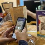 ilustrasi pembeli membayar menggunakan QRIS