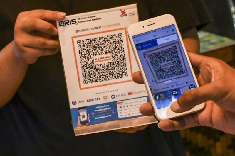 ilustrasi pembeli membayar menggunakan QRIS