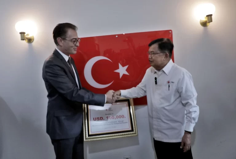 Ketua Umum PMI Jusuf Kalla saat menyerahkan bantuan Duta Besar Turki untuk Indonesia yang diwakili Ömer Orhun Çelikol (10/2/2023).