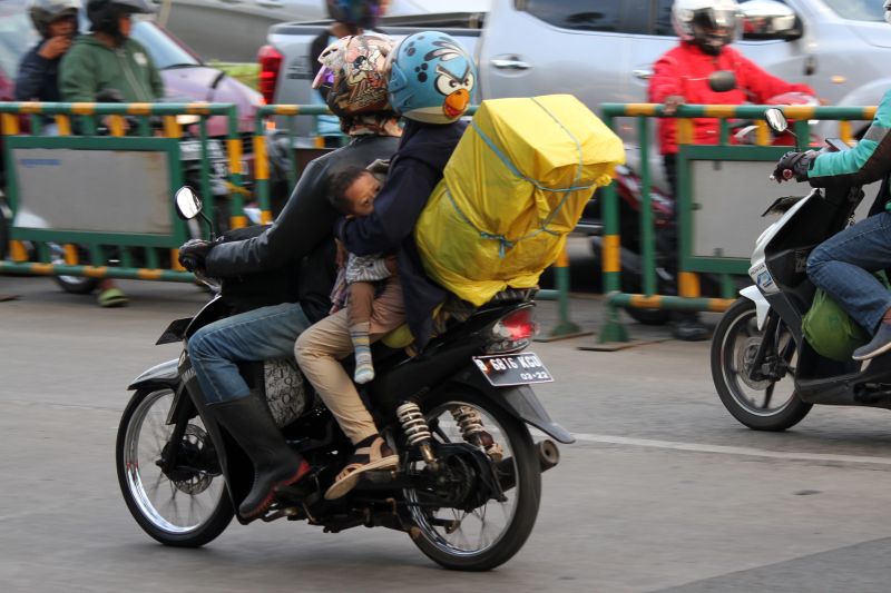 Pemudik sepeda motor dengan membawa anak melintasi Jalan M Hasibuan, Bekasi, Jawa Barat, Selasa (20/6).