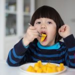 ilustrasi anak makan buah mangga