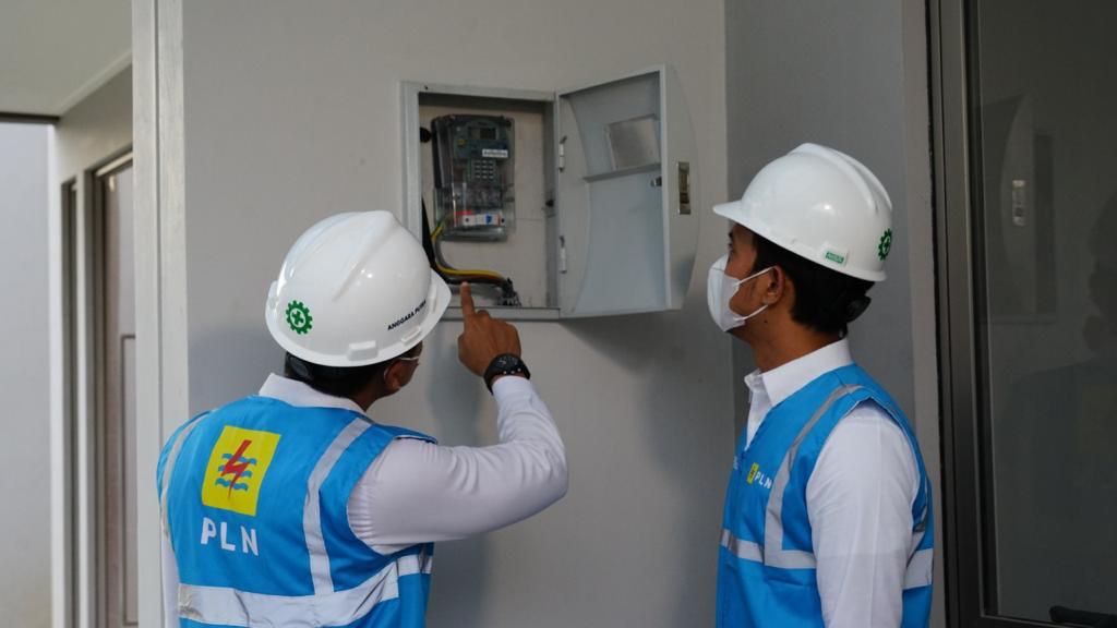 Ilustrasi petugas PLN memeriksa kWh meter milik pelanggan rumah tangga