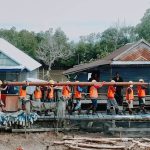 Dengan akses kendaraan berat yang terbatas, petugas PLN bergotong royong memikul tiang seberat 300 kilogram di Desa Akkotengeng, Kabupaten Wajo, Provinsi Sulawesi Selatan