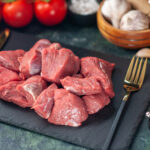 front-close-view-fresh-raw-chopped-meats-cutlery-set-wooden-board